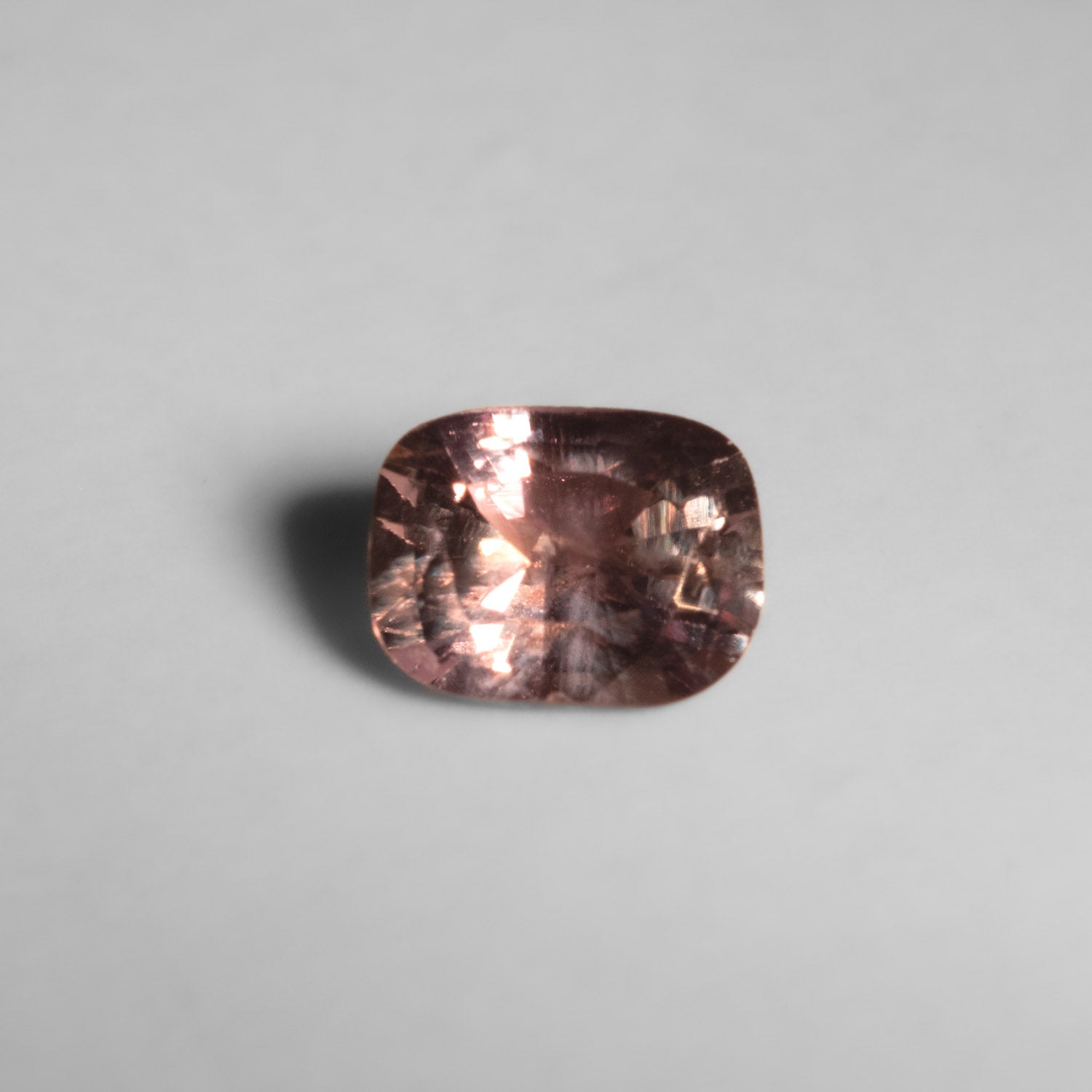 view under incandescent lighting of 1.04ct alexandrite gemstone in gray